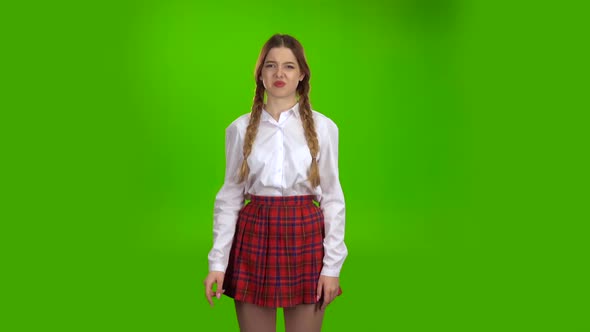 Student in a White Blouse and Pigtails Shows a Fist . Green Screen
