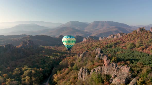 Hot air balloon flying over picturesque rock formation