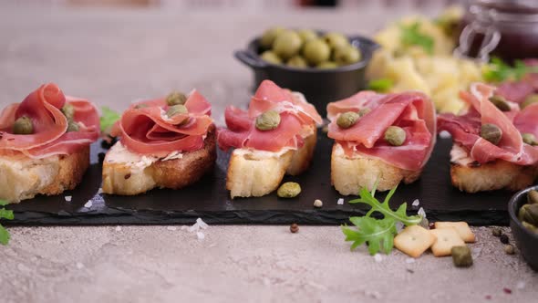 Bruschetta with Prosciutto or Jamon Ham and Cream Cheese on Stone Serving Board