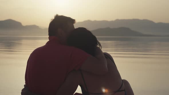 Loving Couple Hugging on the Beach By the Sea at Sunset