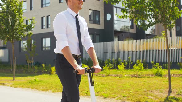 Young Businessman Riding Electric Scooter Outdoors