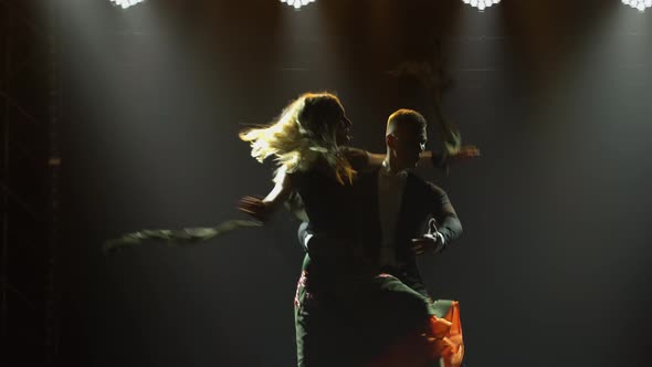 A Man Waltzes with His Partner Woman Circling Her in the Air