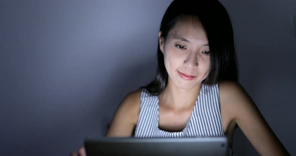 Woman using tablet computer at night 