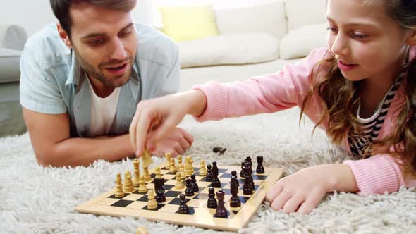 Father and daughter playing chess in the living room