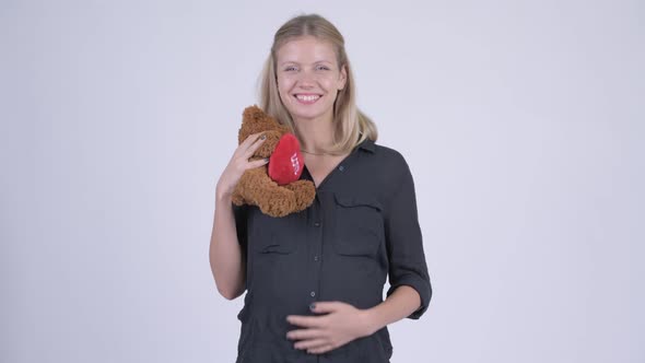Young Happy Pregnant Businesswoman Hugging Teddy Bear