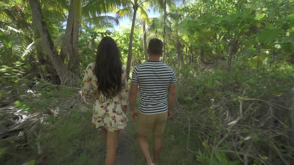 A man and woman couple walking on a path in the tropical islands in French Polynesia