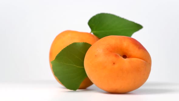 Apricots rotating on white background