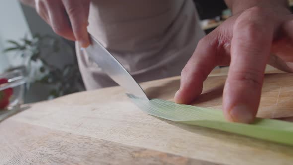 Male Hands Cutting Green Leek Leave