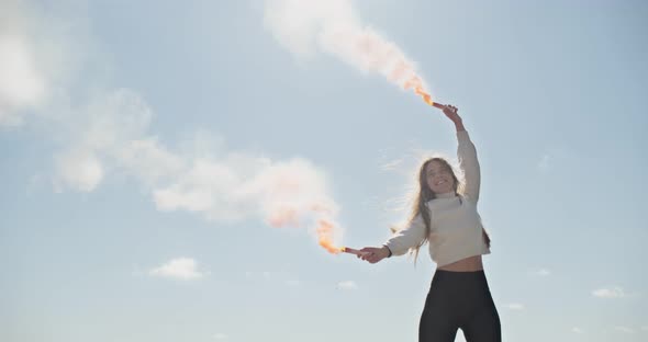 Portrait of Young Attractive Female Who Smiling and Looking at the Camera with Smoke Bombs