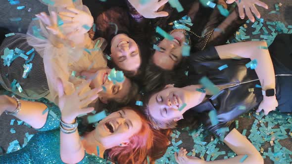Close-up Company of Women Lying on the Floor in Blue Confetti Slow Motion