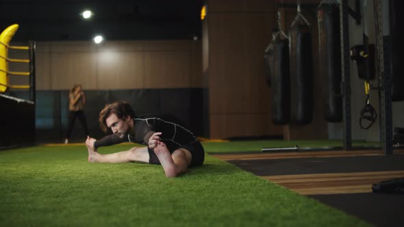 Young Sport Man Doing Splits at Gym. Male Boxer Making Stretching in Sport Club