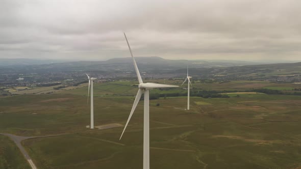 Drone footage of a group of wind turbines on farmland