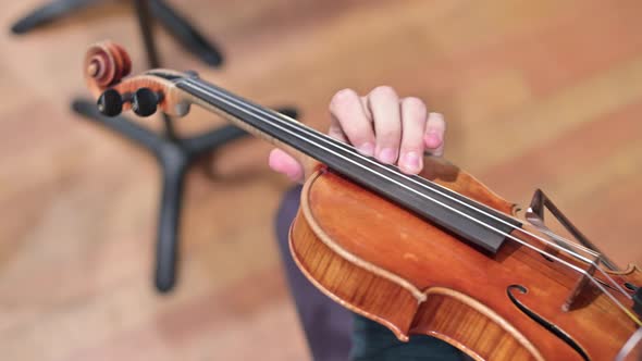 violinist's fingers on violin strings. Playing a musical instrument