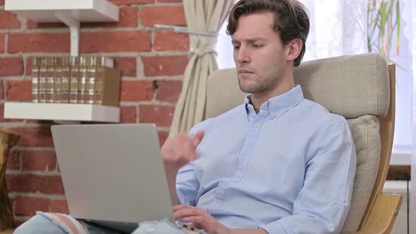 Young Man Thinking and Working on Laptop