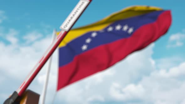 Closing Barrier with QUARANTINE Sign Against Flag of Venezuela