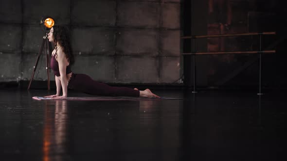 Girl in Burgundy Clothes Doing Yoga. Sports Stretching in the Hall.