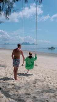 Phuket Thailand Naka Island Couple Men and Woman at a Swing on the Beach