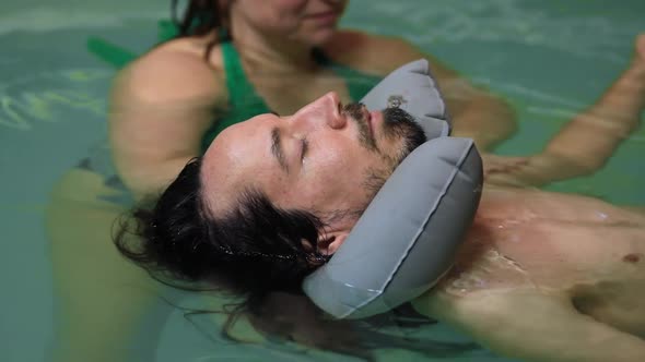 Man Receiving Hand Massage in Swimming Pool