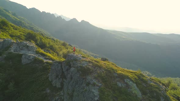 Lost Hiker Holding Map Walking on Rocky Edge High in the Mountains and Looking for Different Route