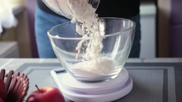 Apple Pie Preparation Series  Pouring Flour Into Glass Bowl Standing on Kitchen Scales