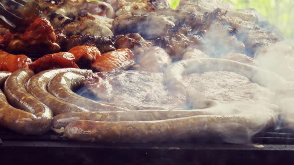 Grilled Sausage On The Flaming Grill. Bearbeque Outdoors with other meat on it, pork, chicken, mitit