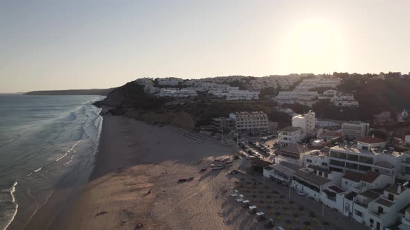 Rotating aerial of Salema beach, Portugal during sunset