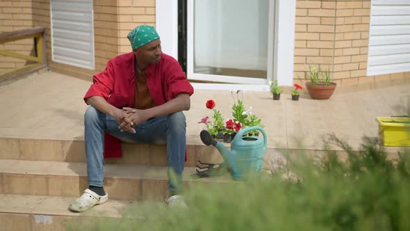 Confident Handsome Man Standing Up From Porch Taking Gardening Tools and Leaving