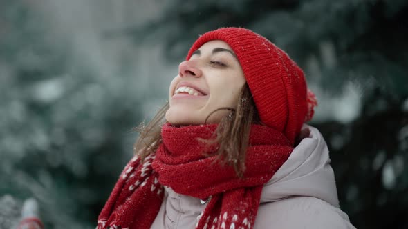 Close Up Slow Motion Candid Smiling Happy Woman in Red Woolen Mittens and Beanie Stands in Park in