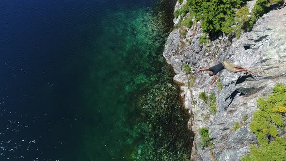 Adventure Lifestyle Concept   Young Adult Takes Risk Diving Off Rock Into Water