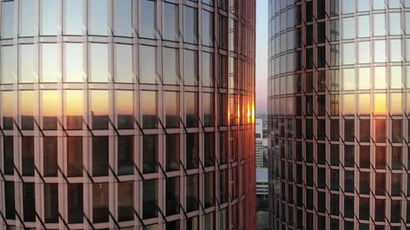 Reflection of golden sunset in glass windows of twin skyscrapers in Riga, Latvia. Close-up Aerial dr