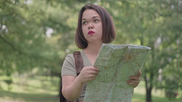 Portrait of Young Concentrated Little Woman Examining Paper Map Standing in Spring Summer Forest