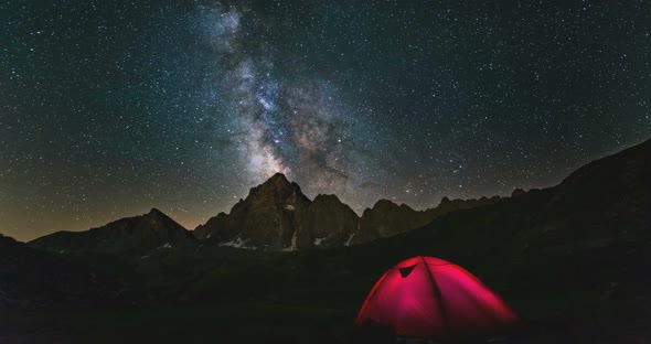 Time Lapse Milky Way Galaxy Stars Over Snowcapped Mountain Peak, Camping Tent Night Sky Stargazing