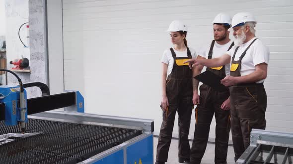 Three Engineers Inspecting Working Plasma Cutter