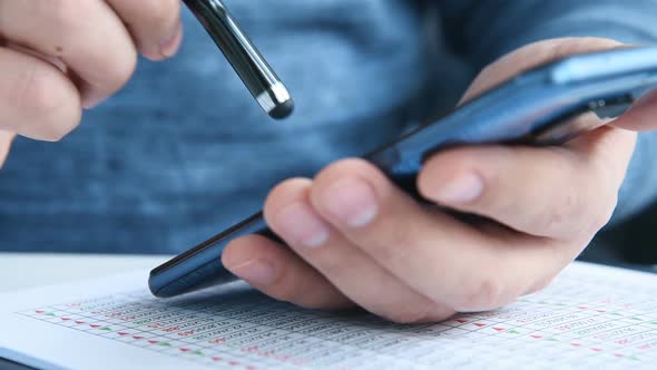 Businessman Using Smartphone With Stock Statistic