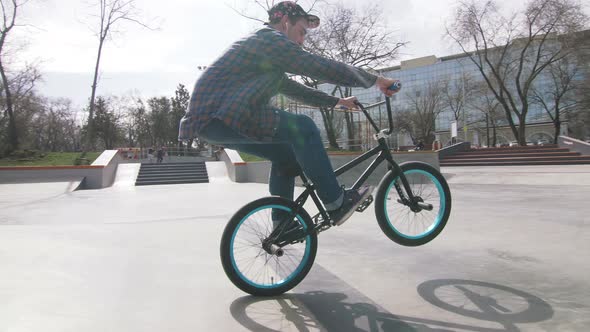 BMX Rider Doing Tricks in Cocncrete Skatepark