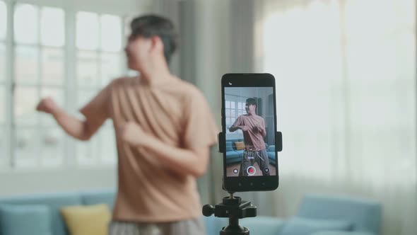 Display Smartphone Of Asian Man Dancing While Shooting Video Content For Social Networks