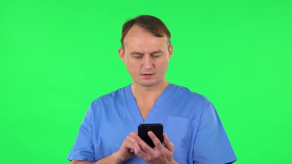 Medical Man Texting on Him Phone. Green Screen
