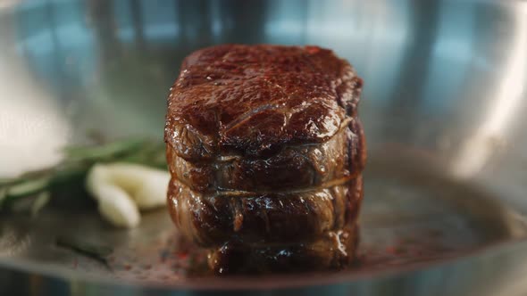 Close-up of a filet mignon being cooked in a frying pan