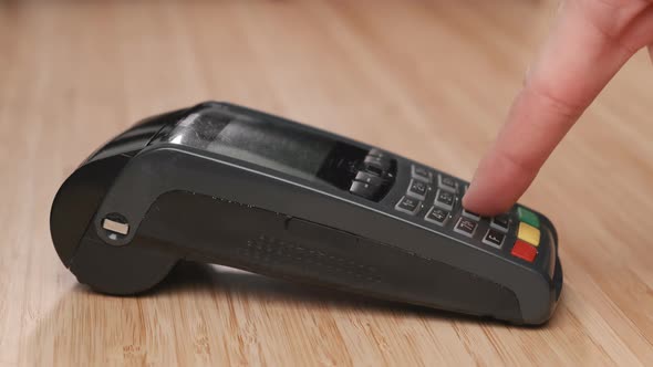 Man Hand Enters Pin Code on the Terminal for Payment