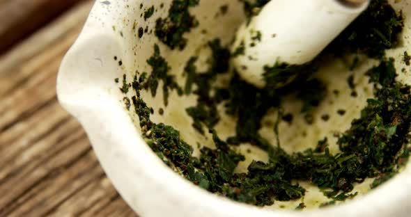 Grinding herb in mortar and pestle