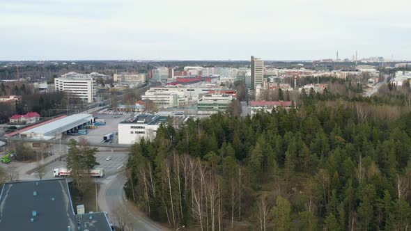 Aerial, tracking, drone shot of buildings in a small town, cloudy, spring day, in Viikki, Finland