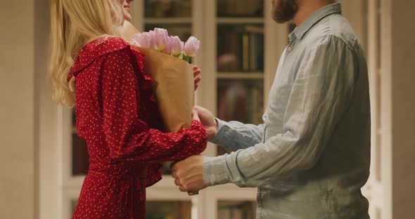 Man Giving a Woman a Bouquet of Flowers