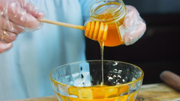 The Cook Pours Honey Into the Transparent Bowl