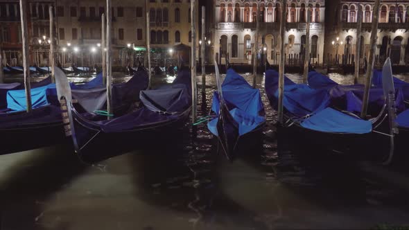 Covered Venetian Condolas Rock on Water Against Night City