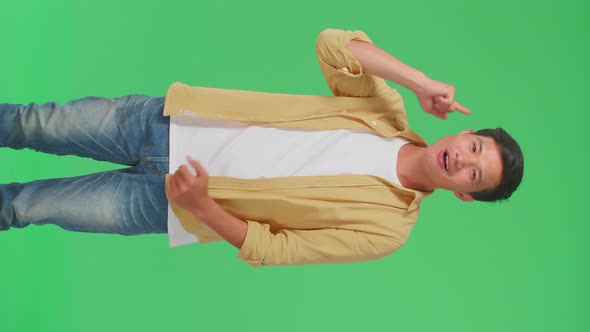 Young Asian Man Thinking About Something Then Raising Her Index Finger In Green Screen Studio