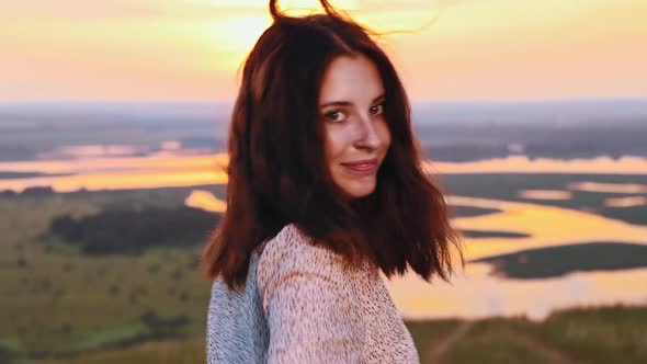 Young Ginger Woman with Pretty Face with Freckles Jumping on Sunset Field and Smiling