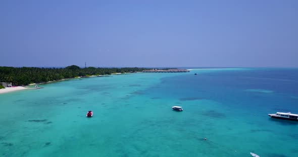 Wide aerial island view of a sunshine white sandy paradise beach and blue water background in vibran