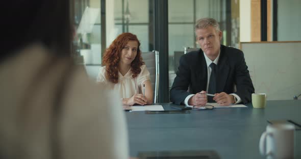 Two business people discuss project ideas with their clients in the office meeting room