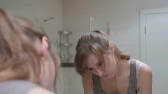Upset Sad Woman Looking at Herself in Mirror