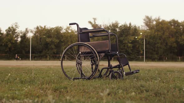 Wheelchair is standing in field, rotation. Concept of consequences accident, diagnosis of paralysis